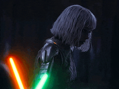 a woman with gray hair is holding two lightsabers in her hands .