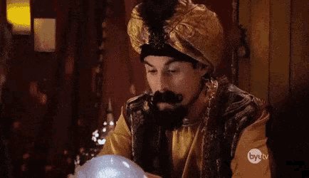 a man in a turban is holding a crystal ball .