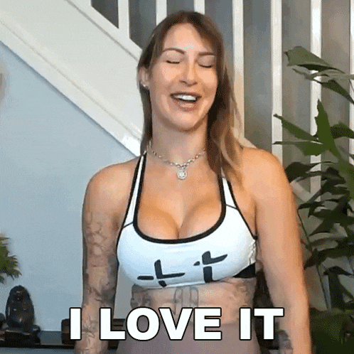 a woman in a sports bra is smiling and says i love it .