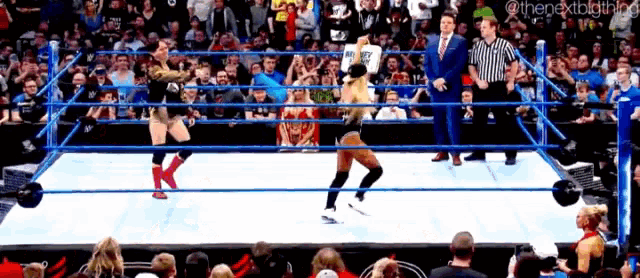 two women are wrestling in a wrestling ring with a referee watching .