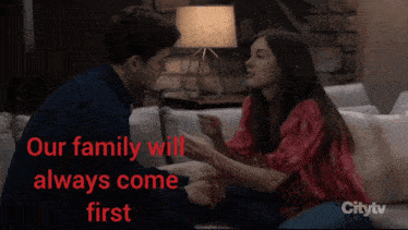 a man and a woman are sitting on a couch with the words " our family will always come first " above them