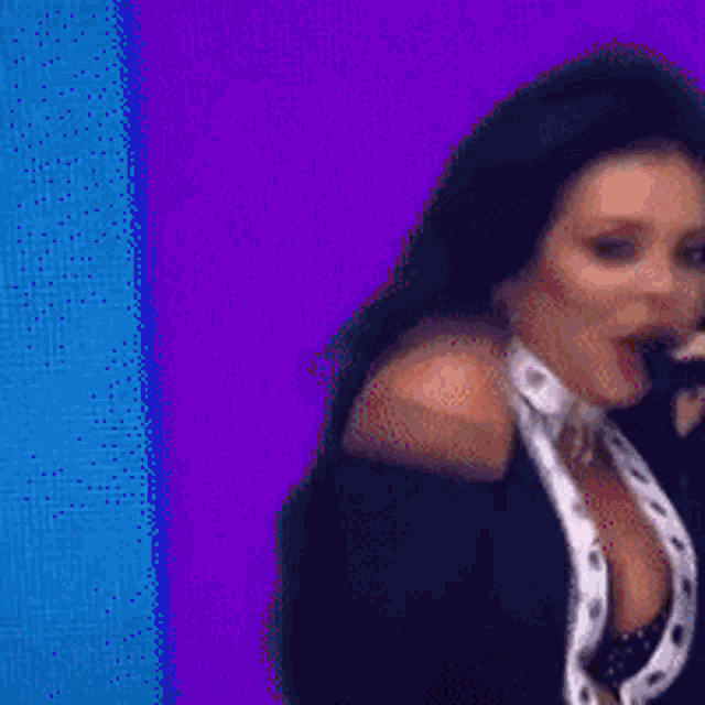 a woman is singing into a microphone while wearing a choker .