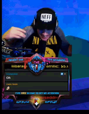 a man wearing headphones and a neff hat is playing a video game
