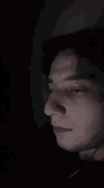 a close up of a man 's face with a dark background