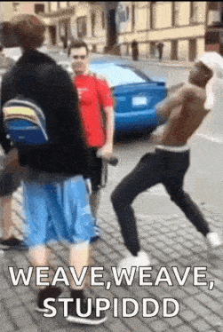 a group of men are standing on a sidewalk and one of them says weave weave stupiddd .
