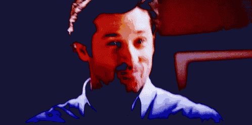 a man in a blue shirt is standing in a room with his arms outstretched