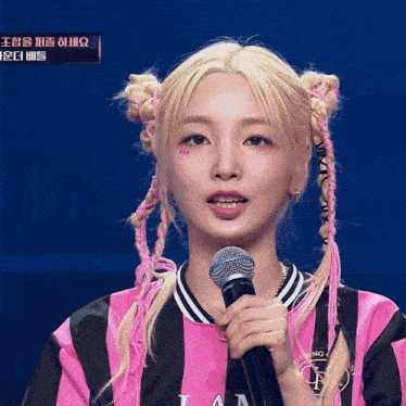 a girl in a pink and black striped shirt holds a microphone