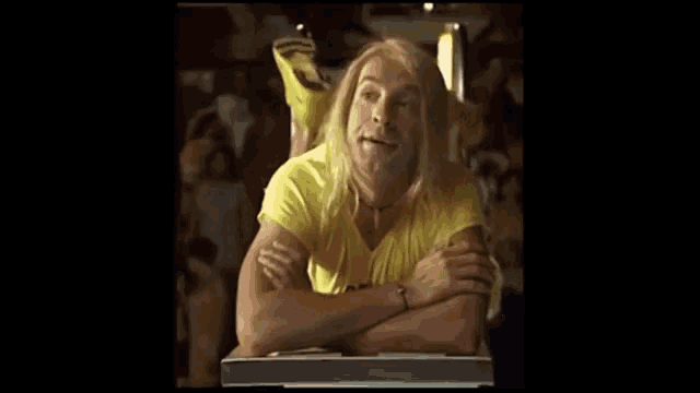 a man in a yellow dress is laying on a table .