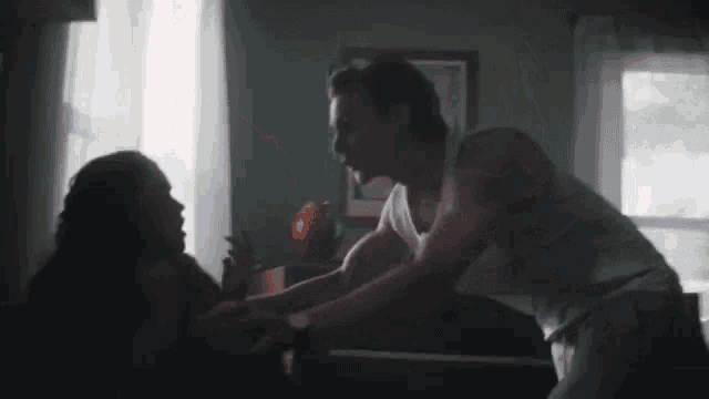 a man and a woman are holding hands in a dark room .