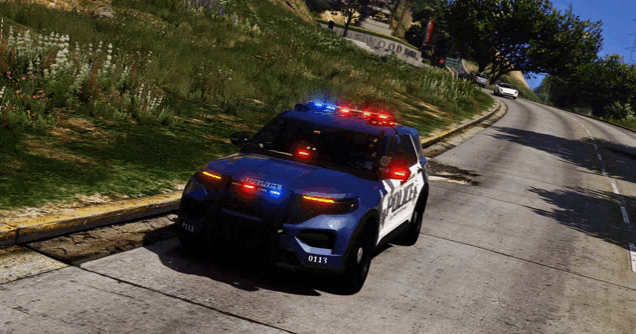 a blue and white police car is driving down a street