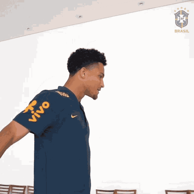 a man holding a bottle of water with a brazilian logo on the back of his shirt