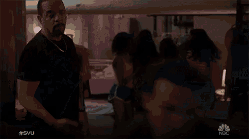 a man in a black shirt stands in front of a group of people with the hashtag #svu on the bottom right