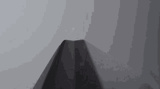 a close up of a black object against a white wall .