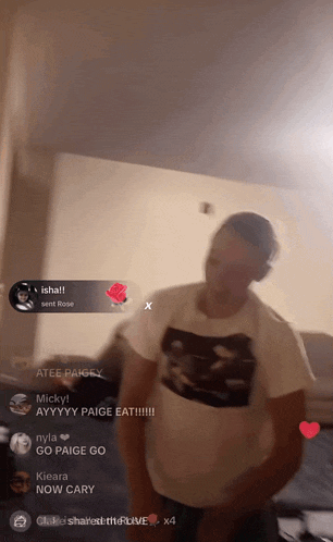 a man in a white t-shirt is dancing in a room with a rose in the corner