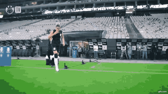 a soccer player is running on the field in front of a tv screen