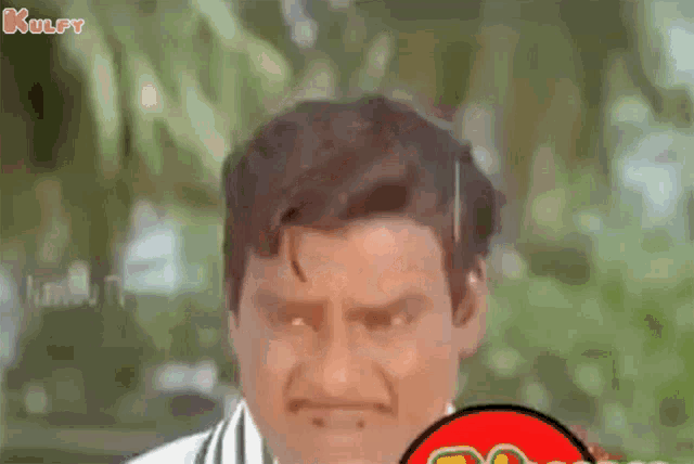 a man with a mustache is making a funny face while holding a red circle .