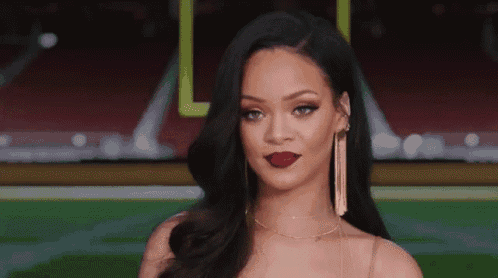 a close up of a woman wearing red lipstick and gold earrings .