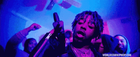 a man is singing into a microphone in front of a crowd of people .