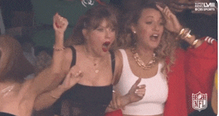 a group of women are sitting in a stadium with a nfl logo in the corner
