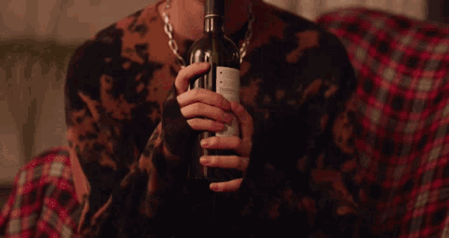 a person is holding a bottle of wine in their hands