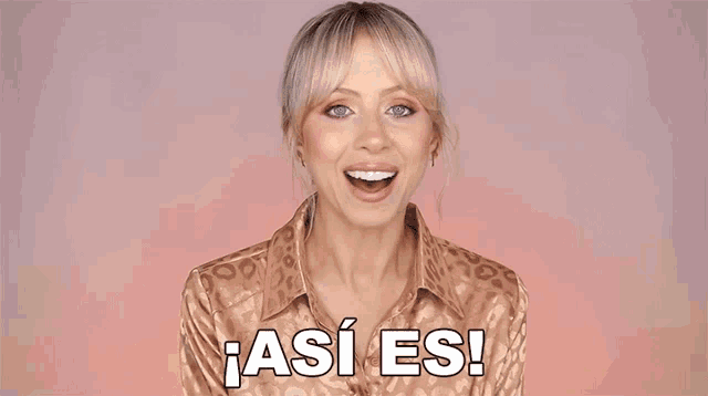 a woman wearing a leopard print shirt is smiling and saying así es