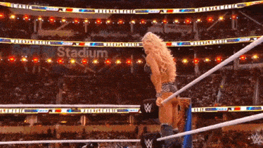 a woman in a wrestling ring with a sign that says stadium