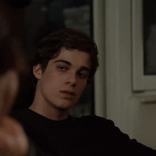 a young man wearing a black shirt is looking at something