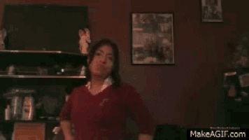 a woman in a red sweater is standing in front of a makeagif.com website