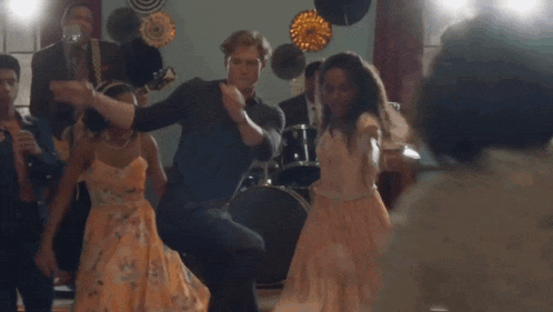 a group of people are dancing in a room with a band .