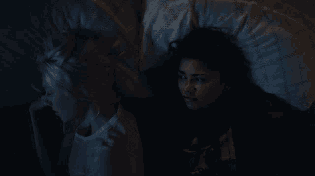 a woman laying in bed with her head on another woman 's lap