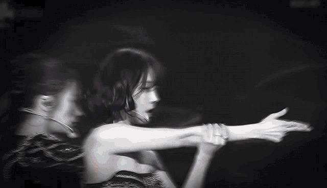 a woman in a strapless dress is singing into a microphone .