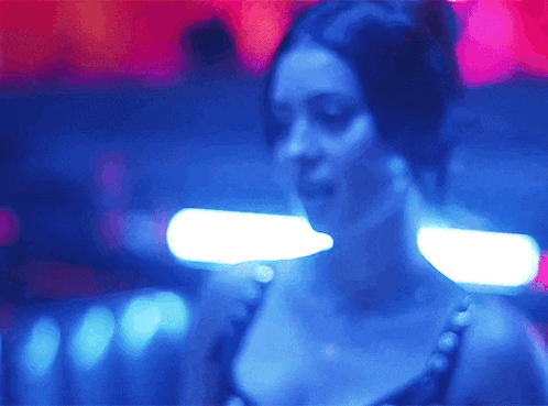 a woman in a blue dress is dancing in a club