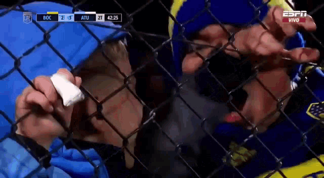 a person behind a chain link fence with the espn logo on the bottom right