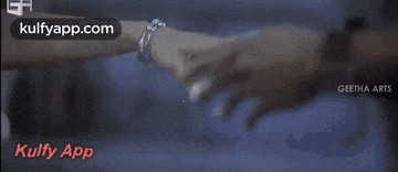 a couple of people holding hands in a dark room with the words kulfy app on the bottom .