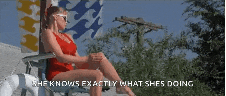 a woman in a red bathing suit is sitting in a chair on a deck .