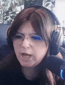 a woman wearing glasses and headphones making a funny face