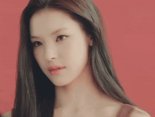 a woman with long black hair looks at the camera