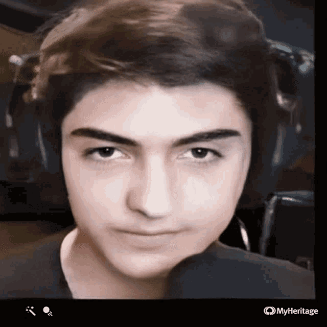 a close up of a young man 's face with headphones and a microphone