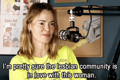 a woman in front of a microphone with the words " i 'm pretty sure the lesbian community is in love with this woman "