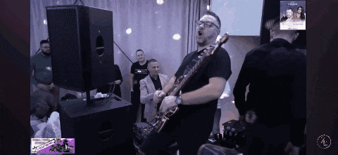 a man playing a guitar in front of a group of men