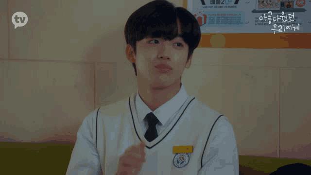 a boy giving a thumbs up in front of a poster that says tv