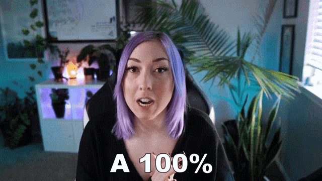 a woman with purple hair says " a 100 % " in front of a palm tree