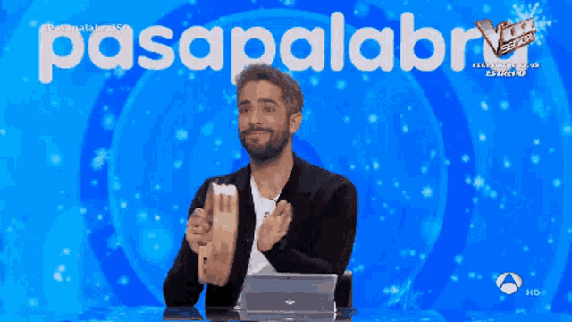 a man holding a drum in front of a blue background with the word pasapalabra