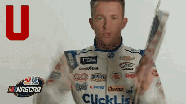 a man in a nascar uniform holds a newspaper