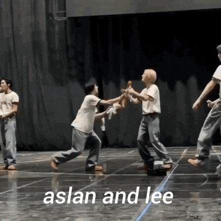 a group of people are dancing on a stage with the words aslan and lee written on the bottom .