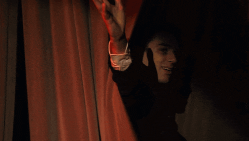 a man in a suit and tie is waving his arm in the air