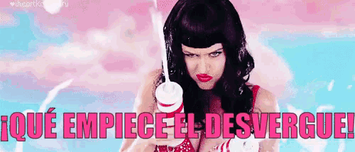 a woman in a wig is holding a cup of milk in her hand and says `` que empiece el desvergue '' .