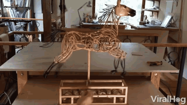 a sculpture of a horse is on a table with the words viralhog on the bottom right