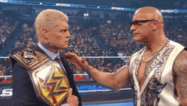two wrestlers are standing next to each other in front of a crowd with the word smack on the screen