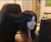 a woman is sitting in a chair looking at a computer screen